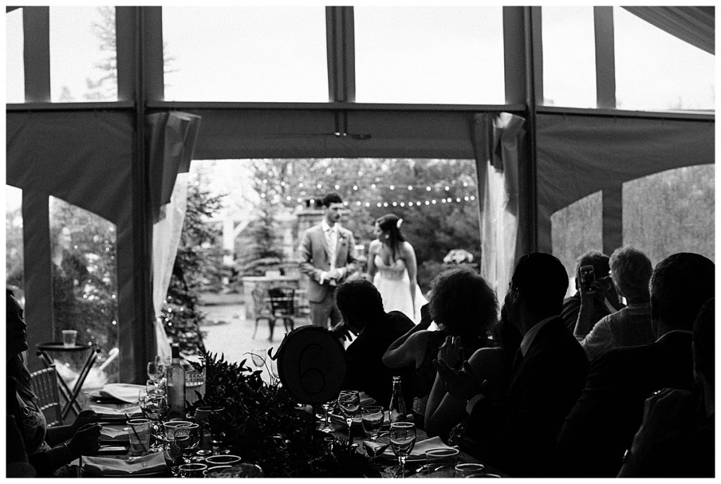Black and white of wedding guests watching bride and groom dance under string lights| Belcroft Estate Wedding| Toronto wedding photographer| Ontario wedding photographer| 3photography