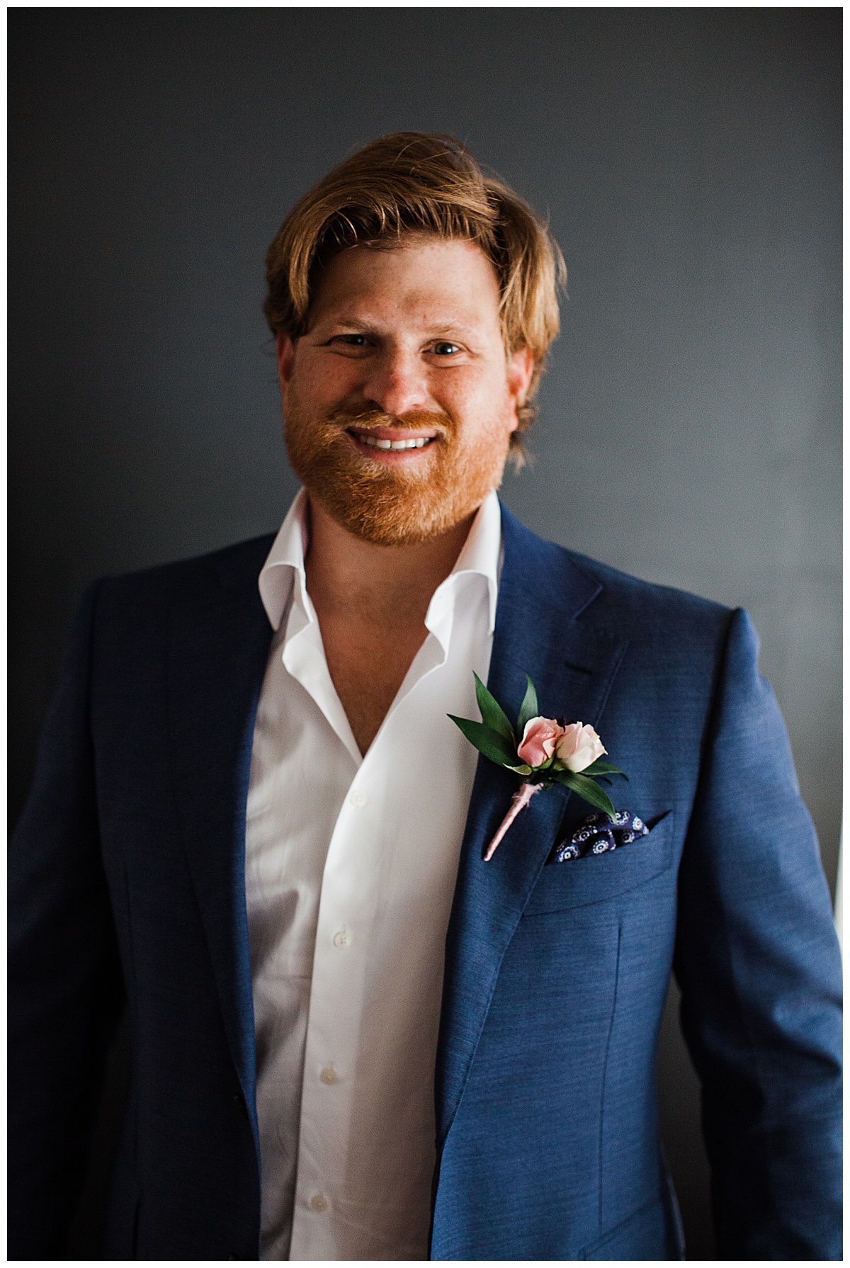 Groom smiling in blue and white suit