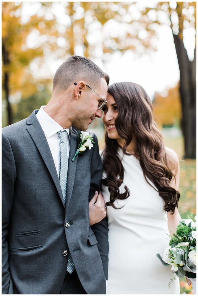 Bride and groom side hugging & smiling in park during fall| Toronto wedding photographer| Toronto engagement photographer| 3photography